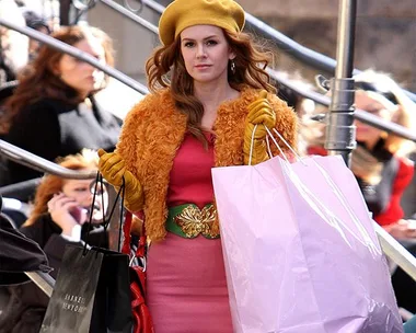 Woman in fashionable outfit holding shopping bags, outdoor setting.