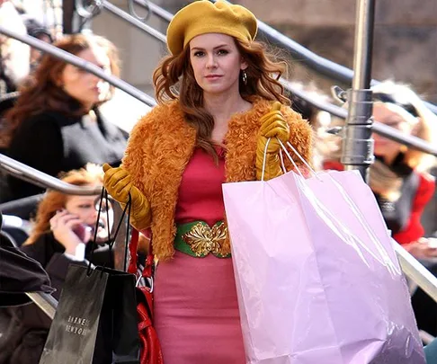 Woman in fashionable outfit holding shopping bags, outdoor setting.