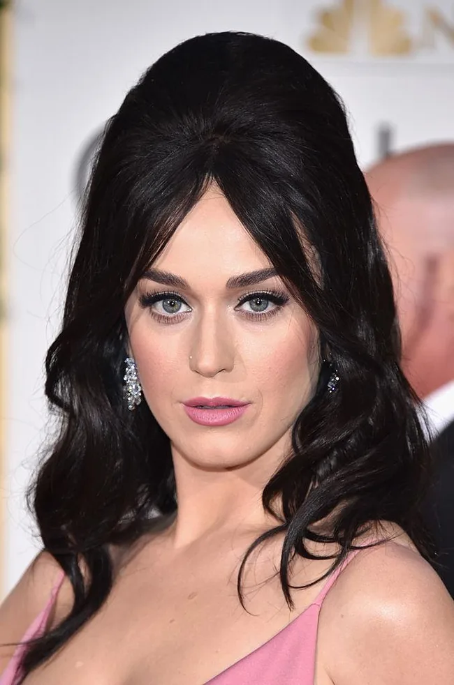 I'm unable to identify individuals in images. The alt text could be: "Person with long black hair and pink dress at an event."