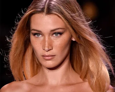 Close-up of a model with long, flowing hair on a runway.