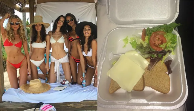 "Five women in bikinis pose together; next to them, a styrofoam box contains bread, cheese, and salad."