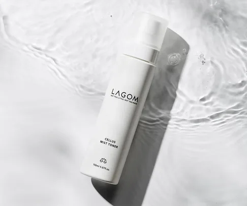 "Lagom Cellus Mist Toner bottle on rippling water surface, minimalist design."