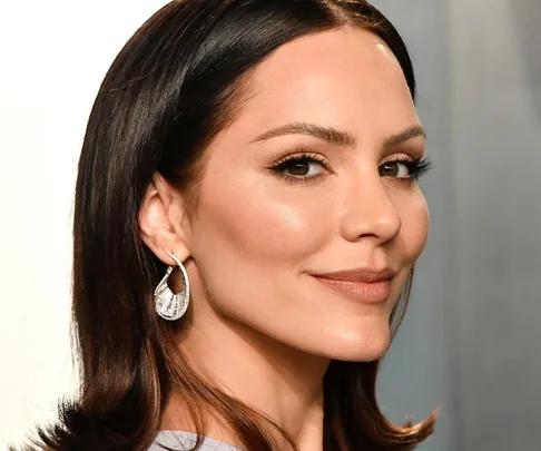 A woman with sleek, shoulder-length dark hair and shimmering earrings at a 2020 Oscars after-party.