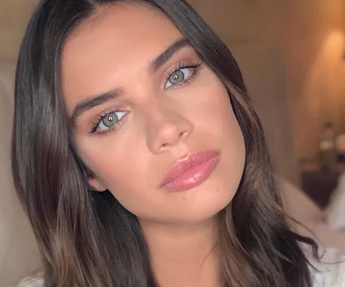 Close-up of a woman with soft makeup, pink lips, and neutral eyeshadow, suitable for a quick work look.