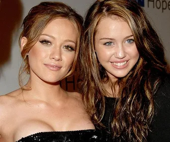 Two young women smiling at a public event, posing closely together.