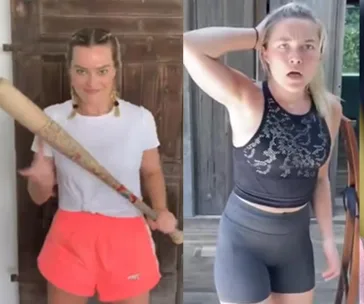 Two women in athletic wear; left holds a bat, right has a surprised expression. Background seems to be a wooden setting.