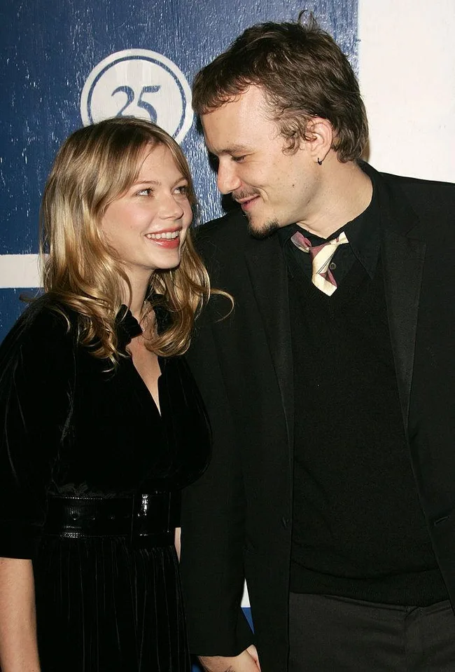 Couple smiling at each other, holding hands, in front of a blue and white background with a "25" symbol.