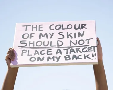 Sign with message against racism: "The colour of my skin should not place a target on my back!!"