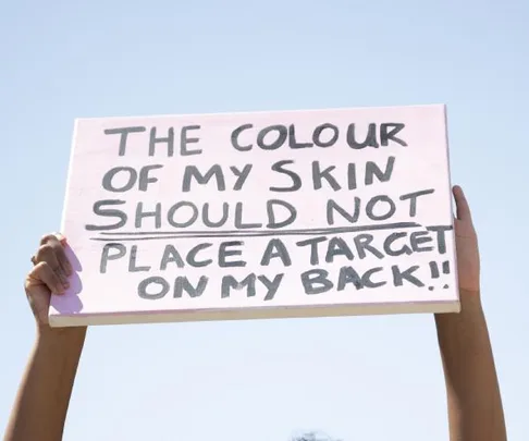 Sign with message against racism: "The colour of my skin should not place a target on my back!!"