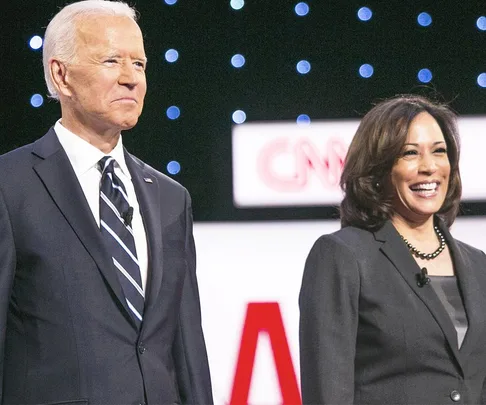 A man and a woman standing on a stage with a CNN logo in the background, smiling at an event.