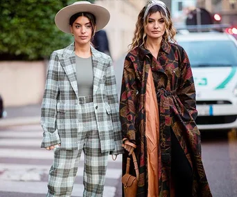 Two women in street style; one in a plaid suit with a hat, the other in a floral coat; Milan Fashion Week 2020.