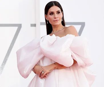 A woman in a glamorous white gown poses on the red carpet at the Venice Film Festival 2020.