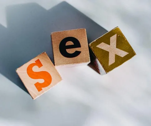 Toy blocks spelling "sex" on a light surface.