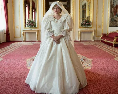 Character in a vintage-style wedding dress stands in an ornate room with red carpeting and gold-framed mirrors.