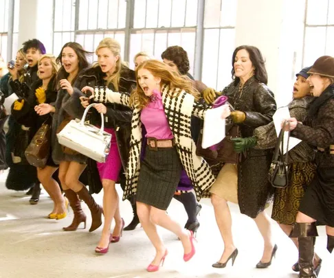 Women rush forward excitedly in a fashion sale frenzy scene, depicting urgency and anticipation.