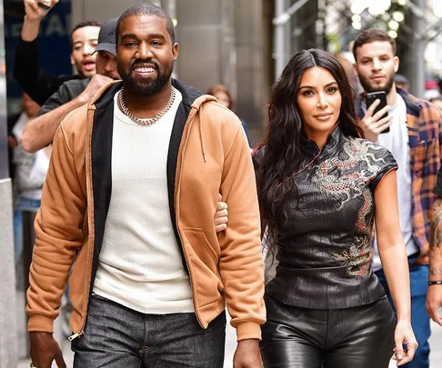 A man and a woman walking in a city street, surrounded by people.