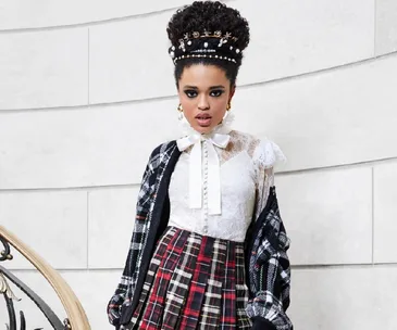 Woman in lace blouse, plaid skirt, and pearl headpiece from Alice + Olivia Fall 2021 collection.