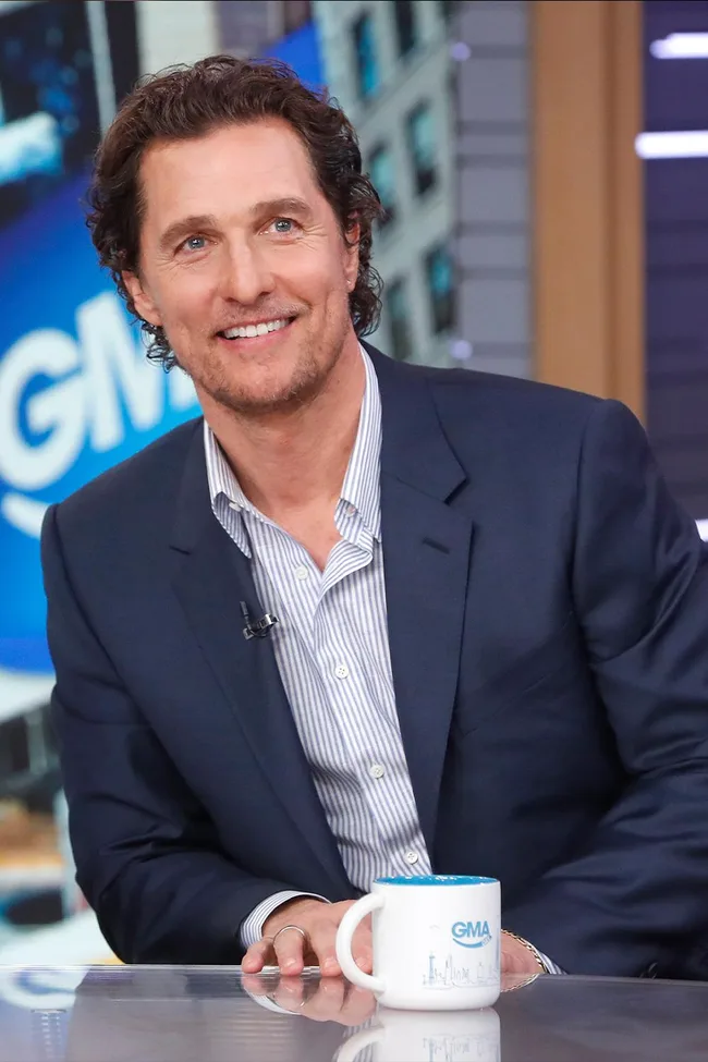 Man in a suit with a mug, seated in a TV studio on "Good Morning America."