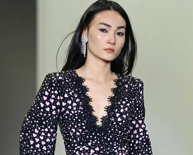 Model at Australian Fashion Week 2021 in Rebecca Vallance black dress with pink hearts and lace, wearing statement earring.