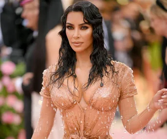 Woman in a sheer beaded dress at a glamorous event.