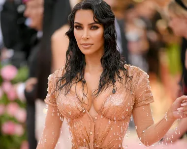 Woman in a sheer beaded dress at a glamorous event.