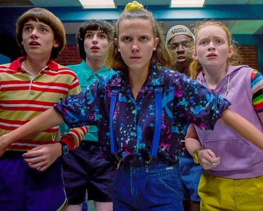 Group of five youths look determined, led by a girl in a patterned shirt. Scene from Stranger Things Season 3.