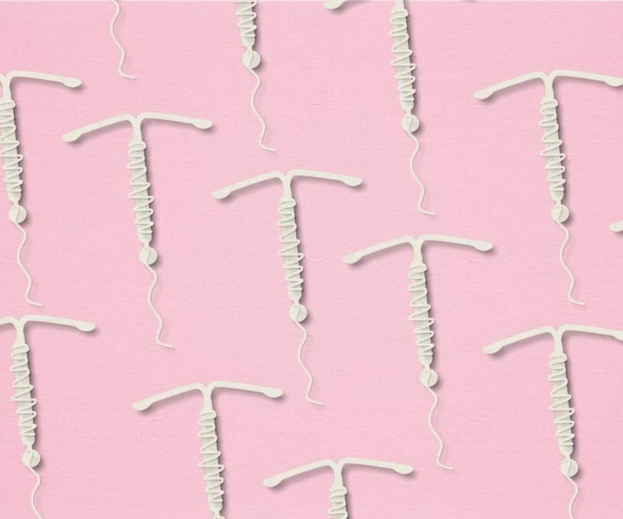 Pattern of white IUD contraceptives on a pink background.
