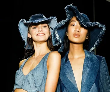 Models wearing frayed denim hats and outfits, smiling at Australian Fashion Week 2021.