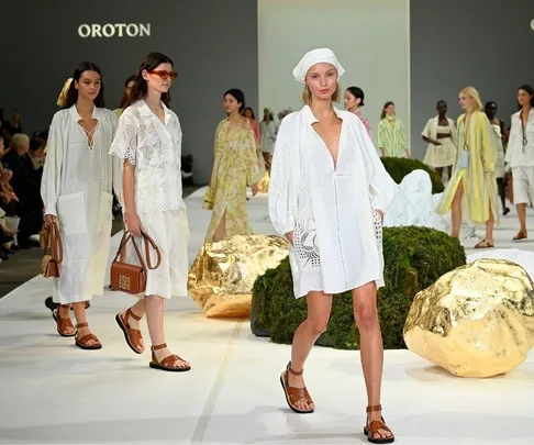 Models walking the runway in white and neutral-colored outfits at the Oroton show, Australian Fashion Week 2021.