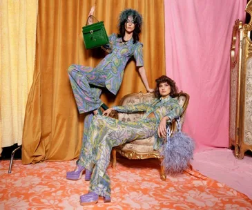 Two models in colorful, floral outfits with bold hairstyles at the Alice McCall show during Australian Fashion Week 2021.