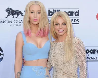 Iggy Azalea and Britney Spears at the 2015 Billboard Music Awards, posing on the red carpet in glamorous outfits.