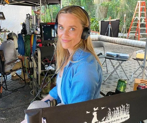 Smiling person with headphones on a movie set chair, "Where the Crawdads Sing" logo visible.