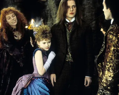 Scene from "Interview with the Vampire" showing characters in period costumes, with a child in a blue dress.