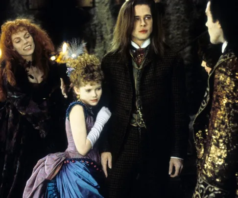 Scene from "Interview with the Vampire" showing characters in period costumes, with a child in a blue dress.