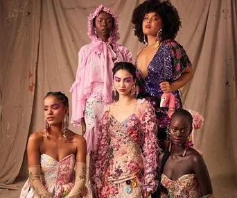 Five models pose in vibrant, floral-patterned outfits at the Romance Was Born show during Australian Fashion Week 2021.