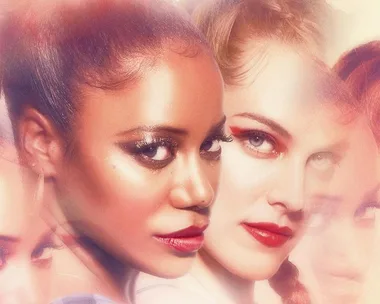 Close-up of two women with dramatic makeup; blurred artistic effect.