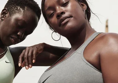 Two women in sports bras pose confidently outdoors, showcasing comfortable and supportive activewear.