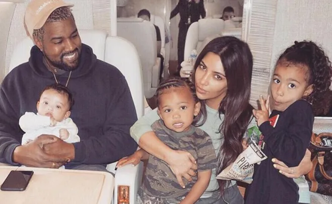 A family sitting together in a cozy space, all smiling and interacting warmly.