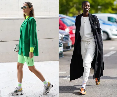 Two individuals in stylish activewear: one in green blazer and shorts, the other in white tracksuit and black coat.