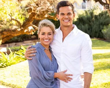 A couple smiling and embracing in a sunny garden setting from The Bachelor Australia.