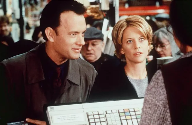 A man and woman stand at a store counter in a busy setting.