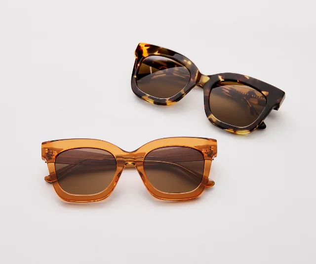 Two pairs of stylish sunglasses with brown lenses; tortoiseshell and amber-colored frames, on a white background.