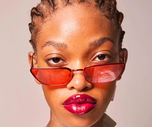 Model with red sunglasses and glossy lips at Paris Fashion Week Spring/Summer 2022.