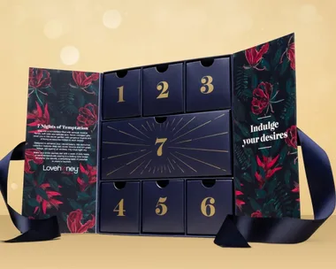 Lovehoney advent calendar with floral design, numbered drawers, and text "Indulge your desires" on side panel.