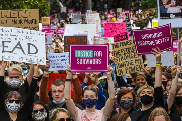 Protesters holding signs demanding justice for survivors, including "Justice for Survivors" and "Survivors Deserve Better."