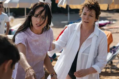 Two women on a beach, one reaching out intensely, possibly from "The Lost Daughter" film.