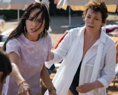 Two women on a beach, one reaching out intensely, possibly from "The Lost Daughter" film.