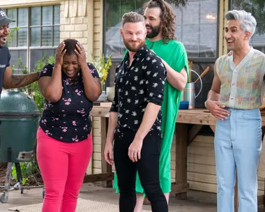 A joyful moment from "Queer Eye" featuring Jereka embraced by the Fab Five outside a house.