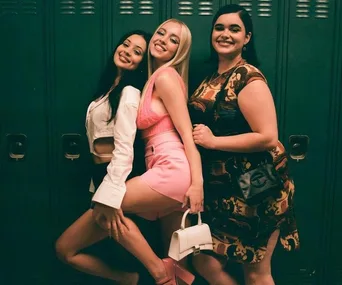 Three women posing playfully in front of green lockers, wearing stylish outfits from Euphoria Season 2.