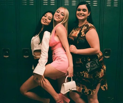 Three women posing playfully in front of green lockers, wearing stylish outfits from Euphoria Season 2.